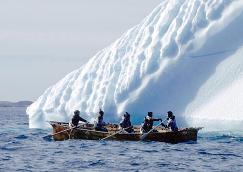 Konebd fra Nanortalik der sejler tt forbi et isfjeld